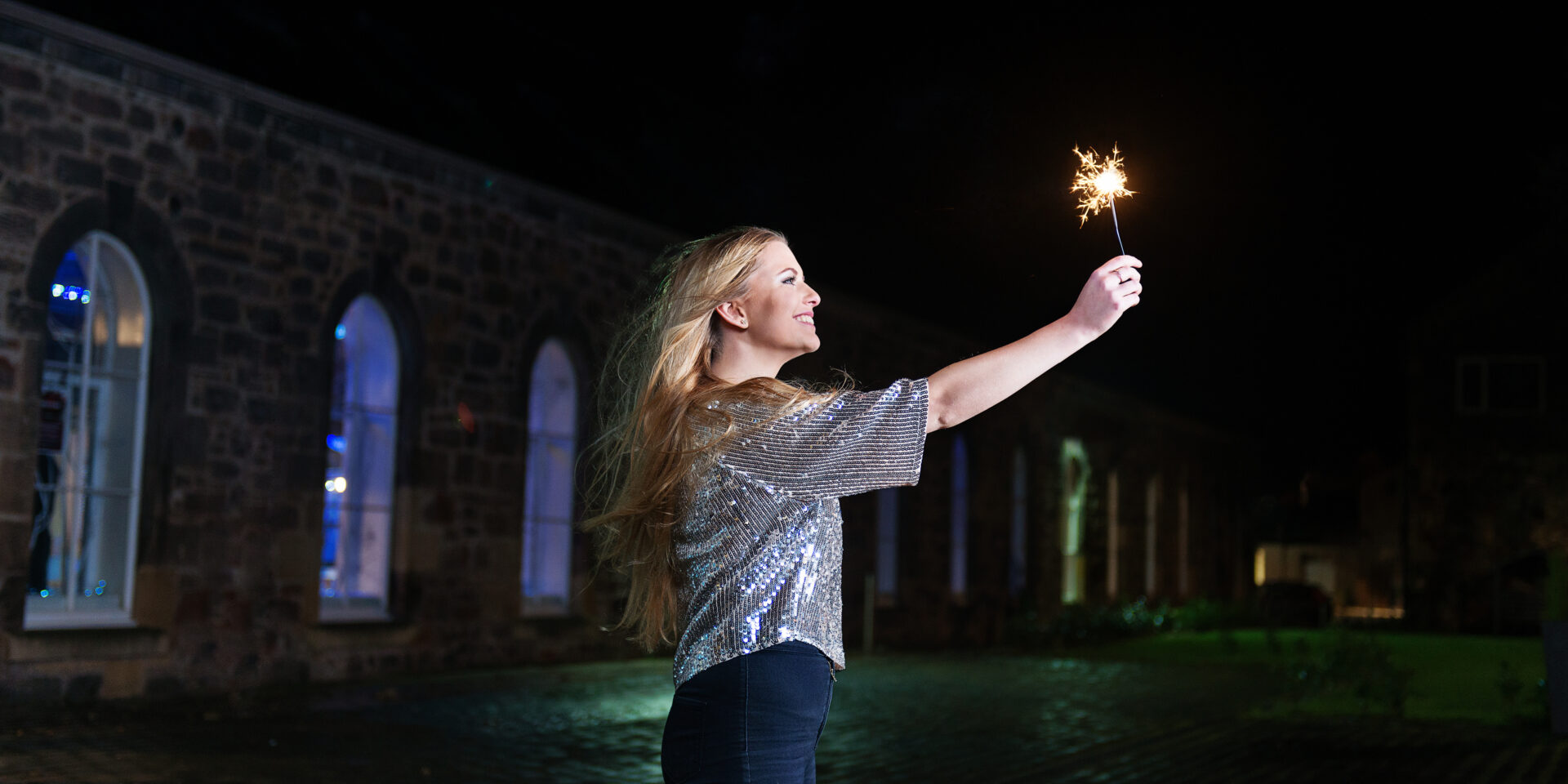 Woman holding a sparkler in the dark