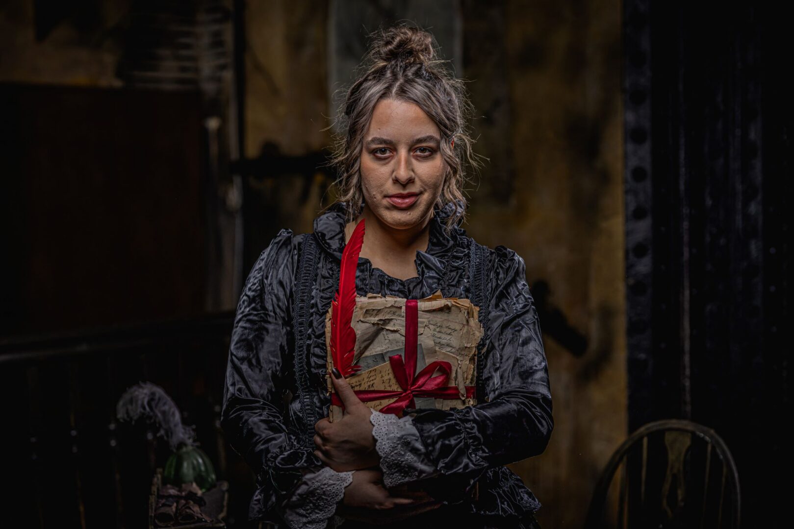 Woman holding a number of paper documents, held together with a red ribbon.