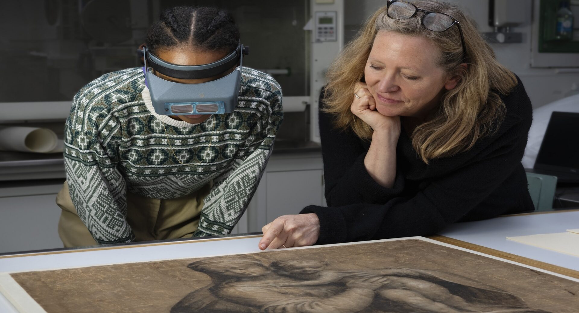 Two women examining a drawing