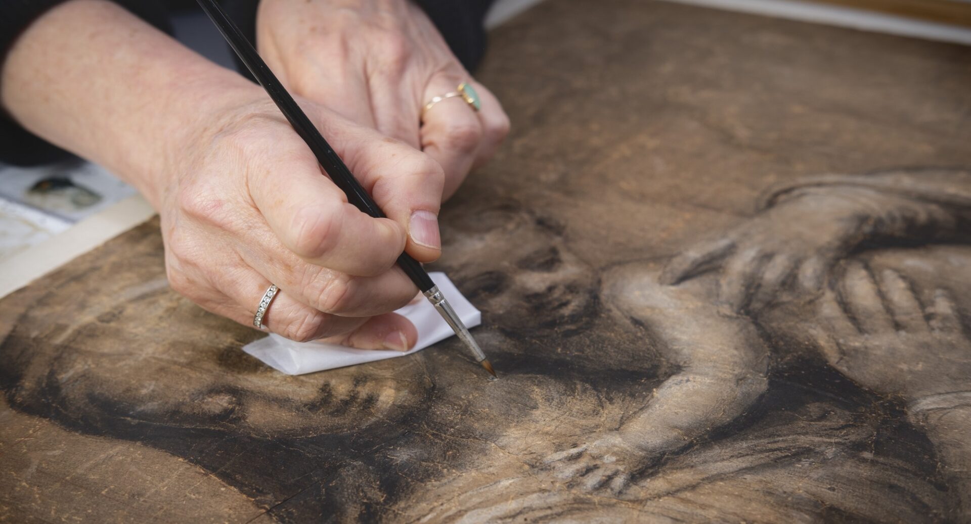 A hand retouching a painting