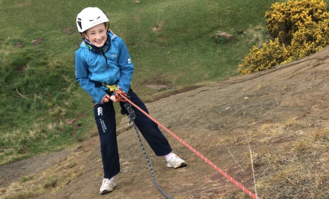 Child abseiling down rock face with Height Club