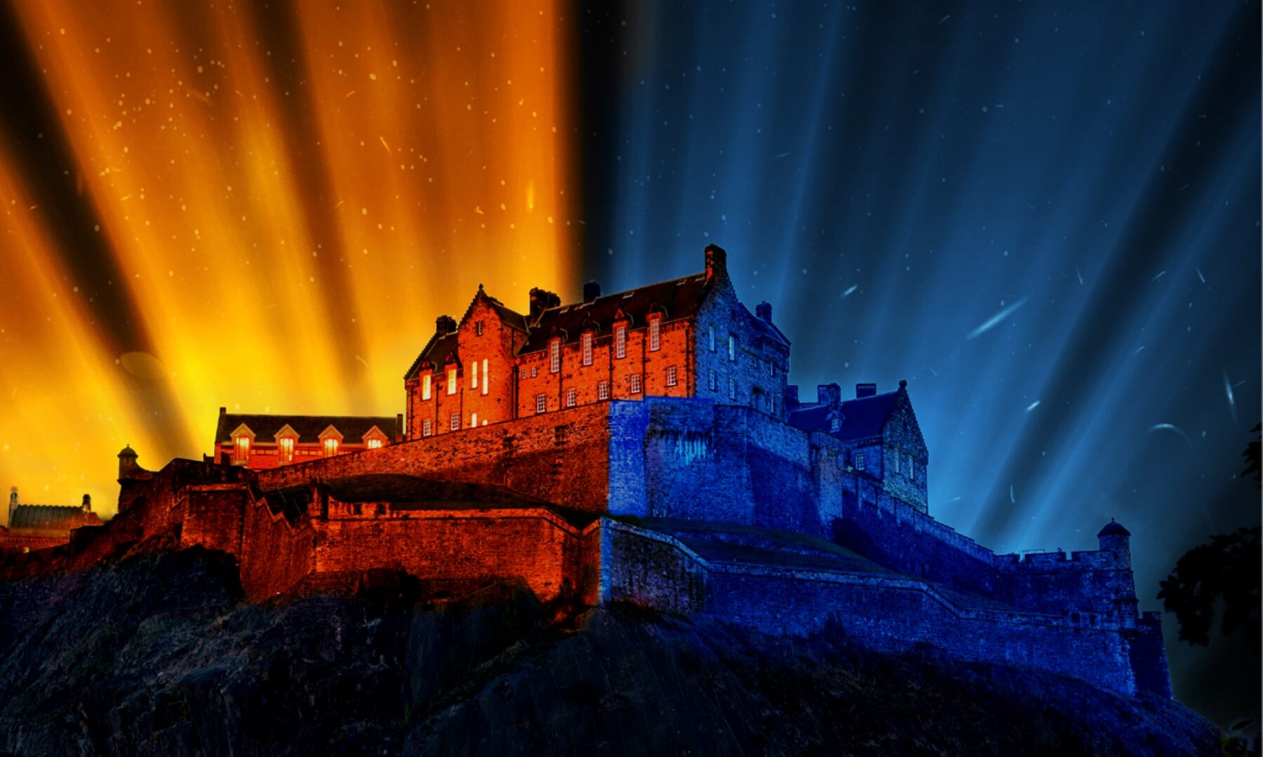 A castle building illuminated by yellow and blue lights.