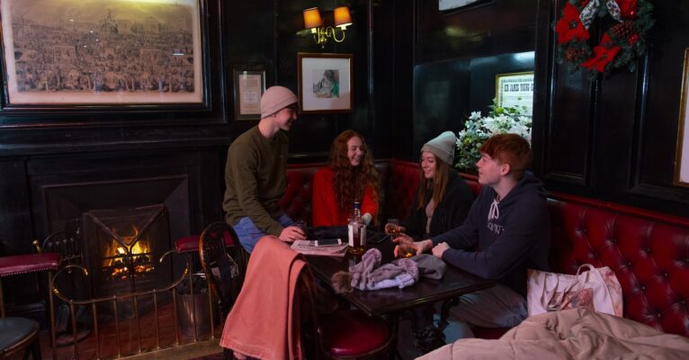 Cosy bar with couples and fire laughing