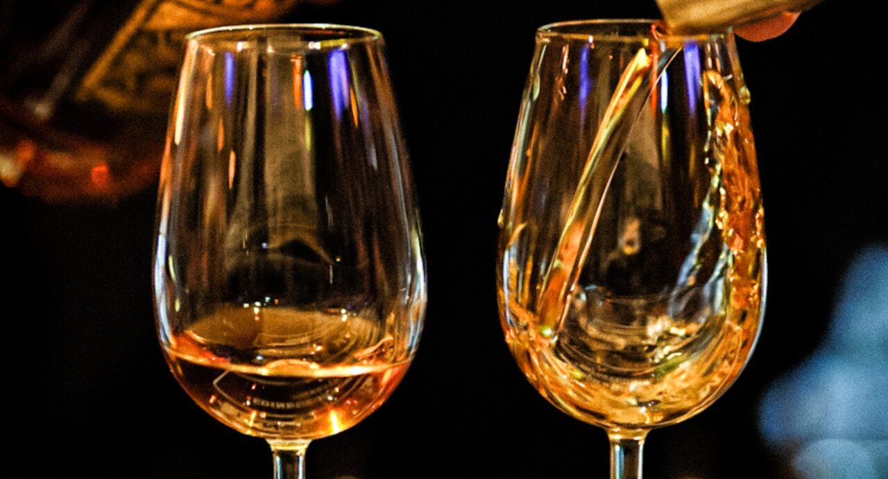 Close up of a drink being poured into a wine glass