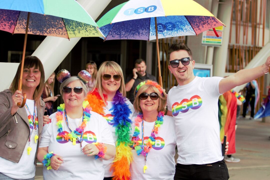 Group of people wearing Pride tshirts and rainbow accessories