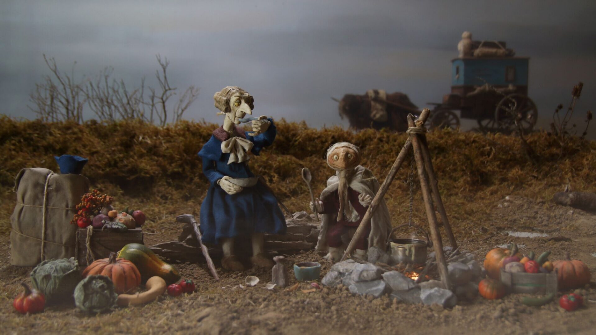 Cartoon image of 2 creatures sitting by a campfire.