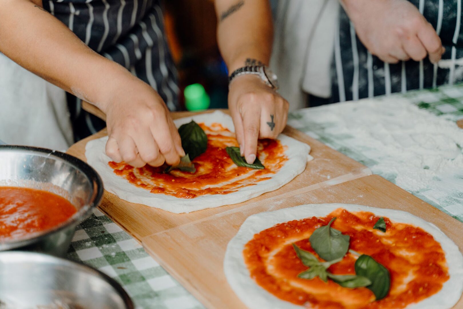 View of person's hands making a pizza.