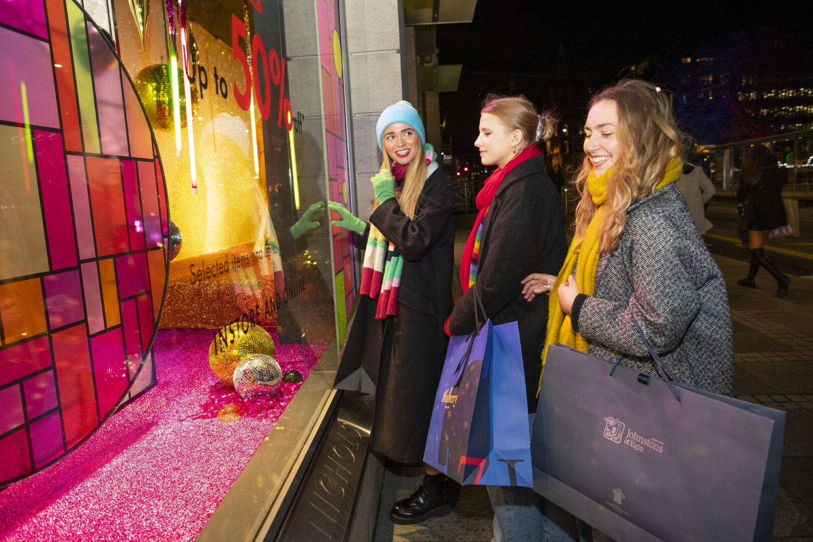 3 friends looking in window of Harvey Nichols