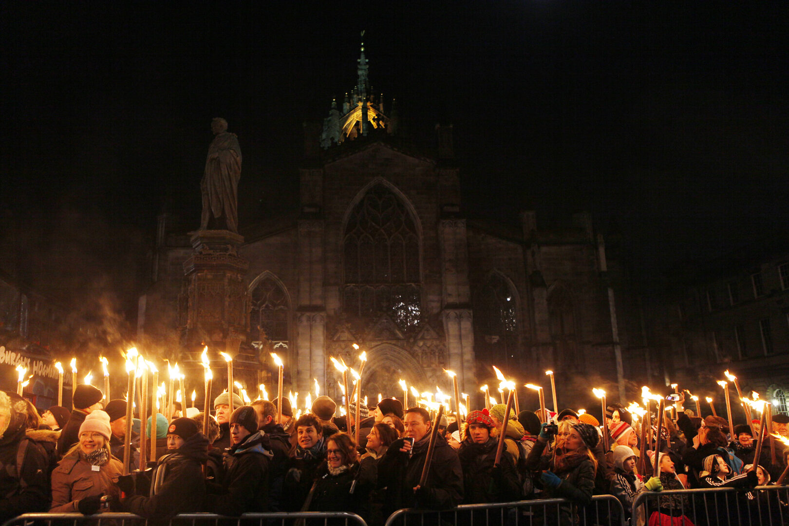 Crowd of people holding flaming torches.