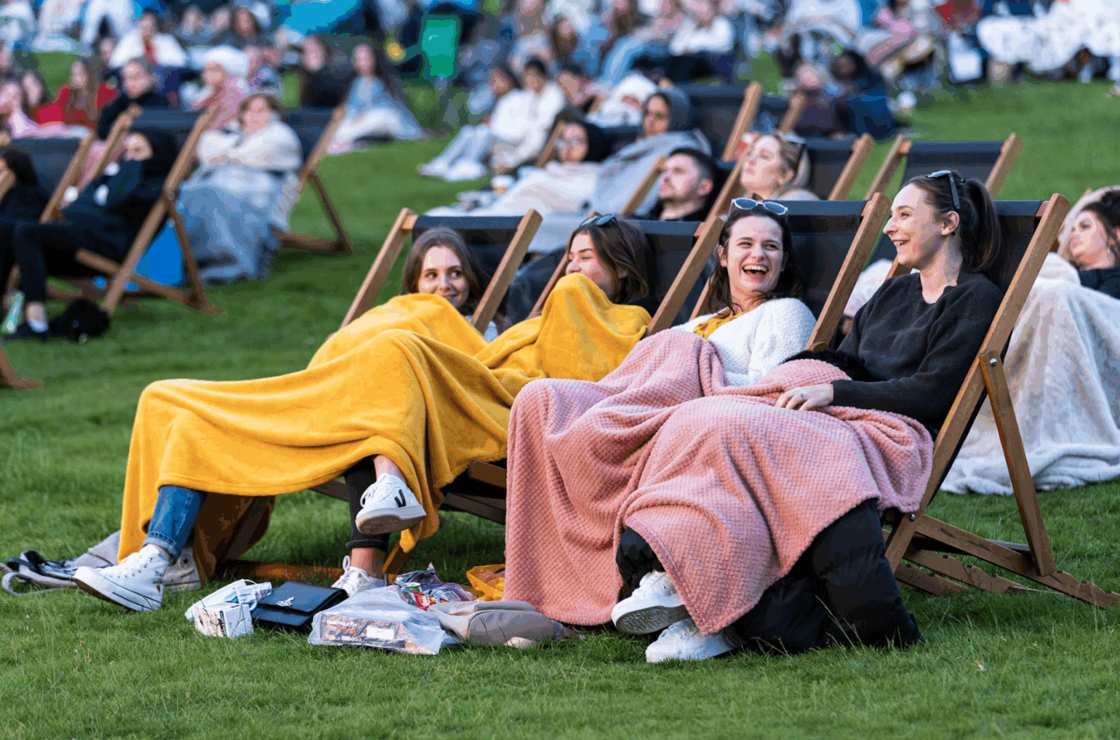 Groups of people sitting outdoors on deckchairs.